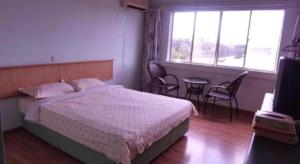 a bedroom with a bed and a table and chairs at Hotel Hung Hung in Kuching