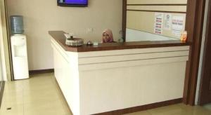 a woman sitting at a counter with a mirror at Hotel Lavender in Alor Setar