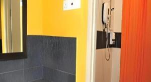 a bathroom with a shower and a phone on the wall at Rumah Tumpangan Abby in Ipoh +58 photos