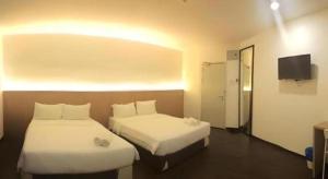a hotel room with two beds and a television at Place2Stay Business Hotel @ Metrocity in Kuching +42 photos