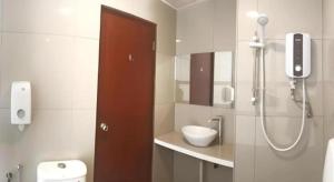 a bathroom with a shower and a toilet and a sink at Place2Stay Business Hotel @ Metrocity in Kuching