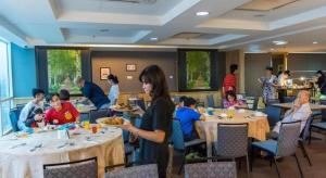 a group of people sitting at tables in a restaurant at MH Hotels Ipoh in Kampong Simee