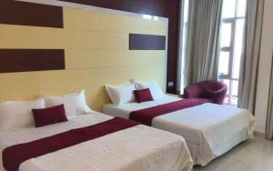 a hotel room with two beds and a chair at LF Hotel Tapah in Kampar +180 photos
