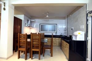 a kitchen with a table and chairs and a television at Yash Villa - Studio Apatrment Villa in Panchgani