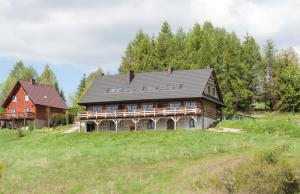 a large wooden house on a hill in a field at Cudne Manowce in Wetlina