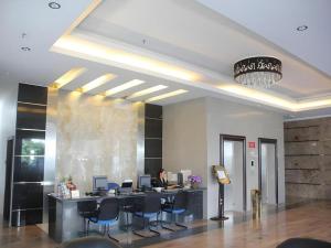 a lobby with a desk with chairs and a person at MB Hotel in Tawau