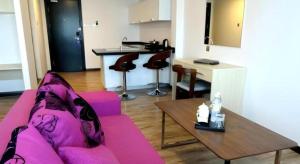 a living room with a pink couch and a table at Kidurong Inn in Bintulu