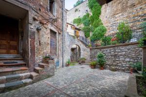 an alley in an old building with potted plants at La casetta nel borgo in Todi