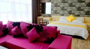 a pink couch in a room with a bed at Kidurong Inn in Bintulu +150 photos
