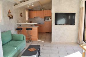 a living room with a green couch and a kitchen at Appartement 3 pièces 6 couchages LEUCATE NATURISME PL010-049 in Port Leucate