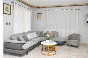 a living room with a gray couch and a table at Villa lujosa bayaguana in Bayaguana
