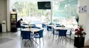 a restaurant with tables and chairs and a man working at Hotel Darulaman Alor Setar in Alor Setar +68 photos