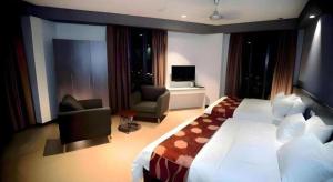 a bedroom with a large bed and a living room at Star-Well hotel in Kuala Lipis