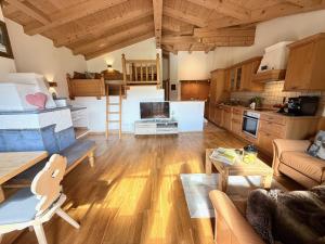 a living room with a couch and a table and a kitchen at Auhäusl Residence for 6 with private Sauna by Belle-Stay in Reith bei Kitzbühel