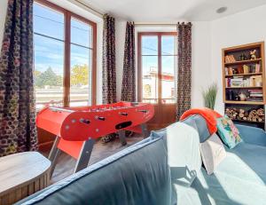a living room with a couch and a play table at Grand T4 Luxe, SPA, Cheminée Baby-foot, Jardin in Aix-les-Bains