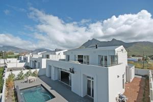 an aerial view of a white house with a swimming pool at Spatalla Holiday Homes in Kleinmond