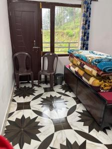 a bedroom with a bed and two chairs and a window at Krishna home stay in Tārna