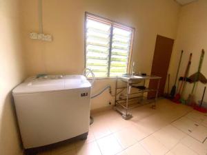 a room with a refrigerator and a window and a table at OYO 90382 Chaah Homestay 2 in Segamat +44 photos
