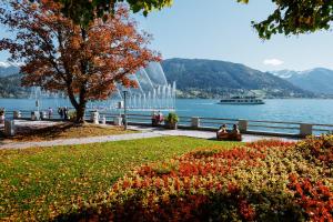a large glass building next to a body of water at das zellersee in Zell am See +136 photos