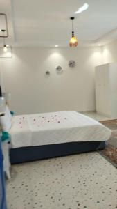 a bedroom with a bed with red flowers on it at شالية برفيزا اليونانية دورين in Taif