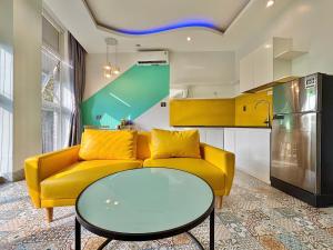 a living room with a yellow couch and a table at Sea House Hotels and Apartments in Vung Tau