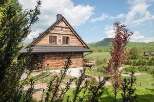 uma casa de madeira no meio de um campo em Cudne Manowce em Wetlina