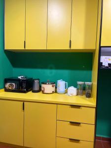 a yellow kitchen counter with pots and pans on it at Roomstay Pondok Aboh in Setiu +9 photos