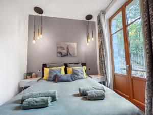 a bedroom with a large bed with two pillows on it at Grand T4 Luxe, SPA, Cheminée Baby-foot, Jardin in Aix-les-Bains
