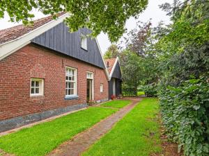 ein Backsteinhaus mit einem Rasenhof neben einem Gebäude in der Unterkunft Cozy Apartment in Enschede near Forest in Enschede