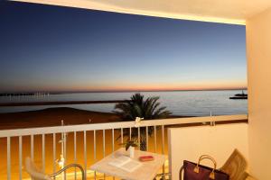 a balcony with a table and a view of the ocean at Hôtel Restaurant Splendid Camargue in Le Grau-du-Roi