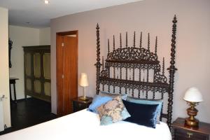 a bedroom with a bed with a large wooden headboard at Quinta do Mosteiro in Felgueiras