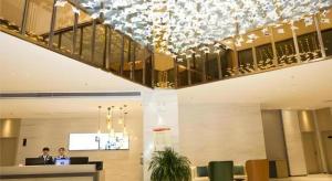 Due persone sedute a una scrivania in una hall di City Comfort Inn Yuzhou Yuwang Square a Xuchang