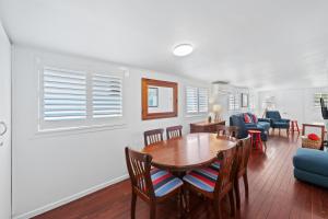 a dining room and living room with a table and chairs at Blue River Shack in Wooli +14 photos