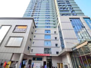 a tall building with many windows in front of it at City Comfort Inn Enshi Jingang Baijia Plaza in Enshi
