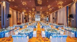 a large banquet hall with blue and white tables and chairs at The Long Red Hotel Daye Huangshi in Huangshi