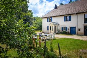 a house with a table and chairs in the yard at Domaine Jurassic Farm in Moirans-en-Montagne