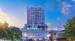 un grand bâtiment avec une enseigne au sommet dans l'établissement City Comfort Inn Chongqing Southwest University Beibei Metro Station, à Huangjuezhen