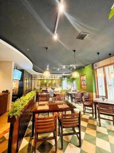 una sala da pranzo con tavoli e sedie in legno di HOTEL SARI KURING INDAH a Serdang
