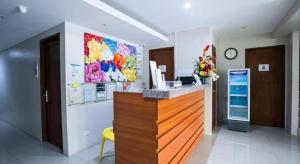 a lobby with a reception desk with a yellow chair at Hotel Fleur de Liz in Panglao
