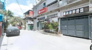 a building with two garage doors on a street at RedDoorz @ Gerlins Lodge Two in Manila
