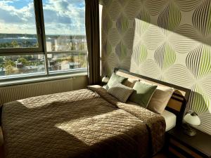 a bedroom with a bed and a large window at Panoramic sea-view penthouse in Klaipėda