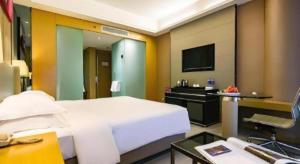 西安市にあるRamada by Wyndham Xi'an Bell Towerのベッドと机とテレビのある寝室