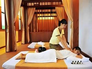 ソンクラーにあるGreen World Palace Hotelのホテルの部屋で男性がマッサージを受けている女性