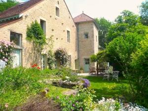 una gran casa de piedra con un jardín delante de ella en Clos de Fougères - Domaine intégral, en Montoillot