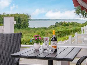 a bottle of wine and glasses on a wooden table at 4 person holiday home in Aabenraa in Aabenraa