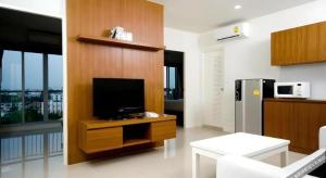 a living room with a television on a wooden wall at Pannapat Place in Bangkok