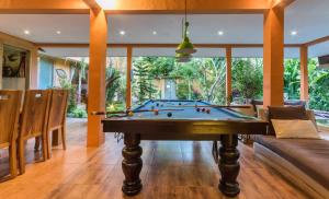 a pool table in the middle of a living room at Villa Odil, Great Value 700m beach & 15m pool in Seminyak