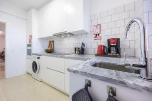 Una cocina con gabinetes blancos y un fregadero. en Casa Tessa, en Porches