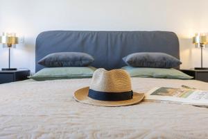 un sombrero de paja sentado en la parte superior de una cama en Casa Tessa, en Porches