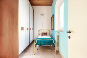 a small room with a bed with a blue wall at Varenna Wonders by Quokka 360 - Lakeside villa with breathtaking view in Fiumelatte +40 photos